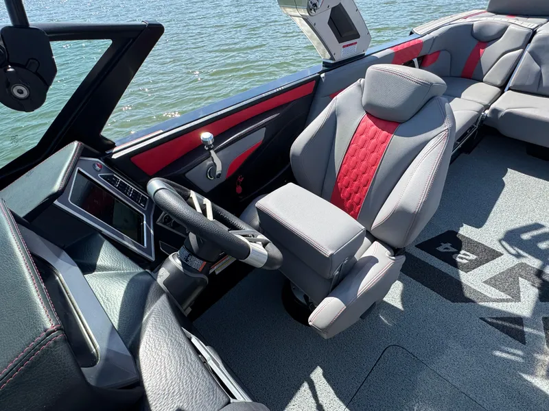Slide: The Image of 2022 MasterCraft XT24 boat interior with modern dashboard and comfortable seating on the water. - 9