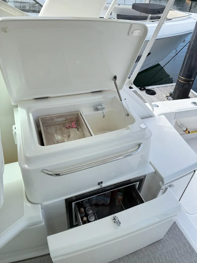 Slide: The Image of Open storage compartment and mini fridge on 2020 Tiara Yachts 39 Coronet boat. - 10