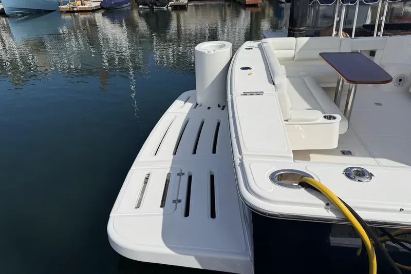 Slide: The Image of 2020 Tiara Yachts 39 Coronet, rear deck view with seating and table, docked in marina. - 3
