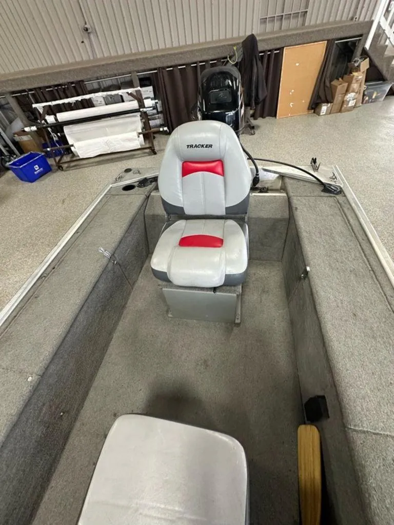 Slide: The Image of 2012 Bass Tracker Panfish 16 boat interior with seating and motor in a garage. - 7