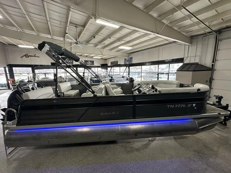 Slide: The Image of 2022 Crest Classic LX 220 SLRC CPT pontoon boat displayed in a showroom. - 21