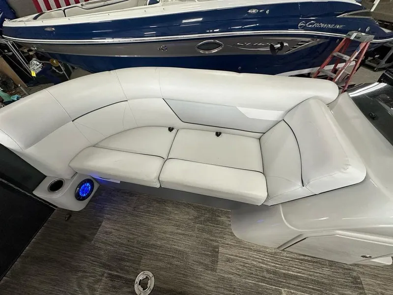 Slide: The Image of 2022 Crest Classic LX 220 SLRC CPT boat interior with white seating and blue speaker. - 4