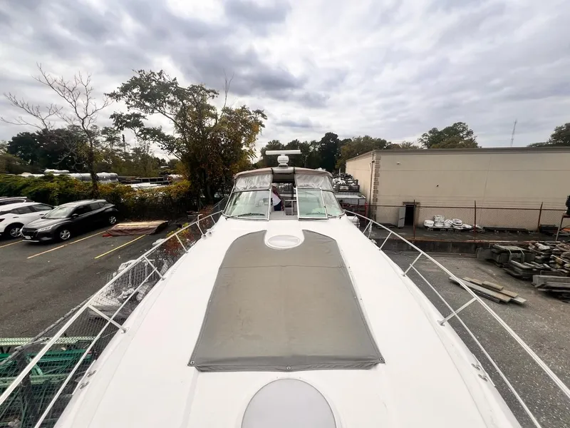 Slide: The Image of 2001 Cruisers Yachts 3870 Express on land, showcasing spacious deck and sleek design. - 12
