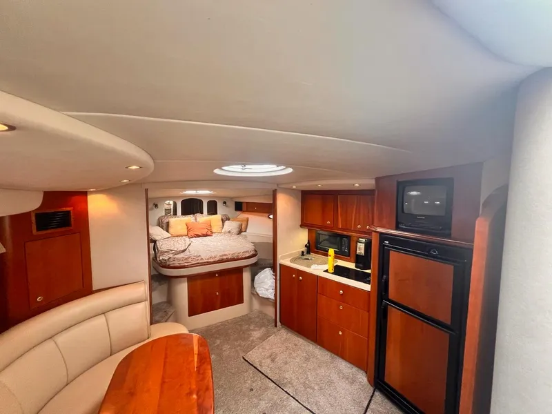 Slide: The Image of Interior of 2001 Cruisers Yachts 3870 Express, featuring kitchen and cozy sleeping area. - 14