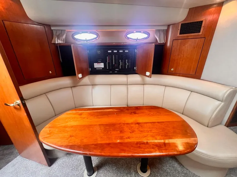Slide: The Image of 2001 Cruisers Yachts 3870 Express interior with wooden table and beige seating. - 17