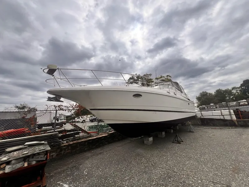 Slide: The Image of 2001 Cruisers Yachts 3870 Express on dry dock under cloudy skies. - 3