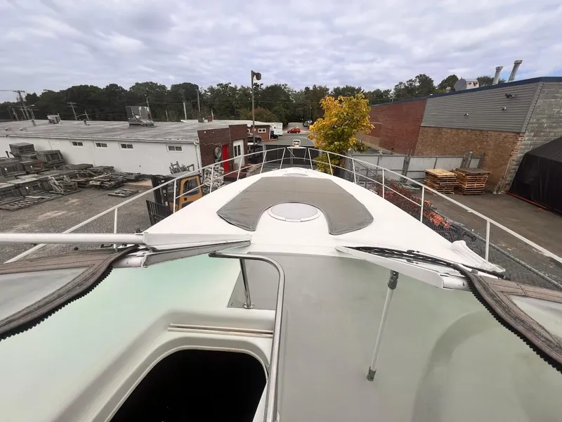 Slide: The Image of 2001 Cruisers Yachts 3870 Express boat docked in an industrial area. - 13