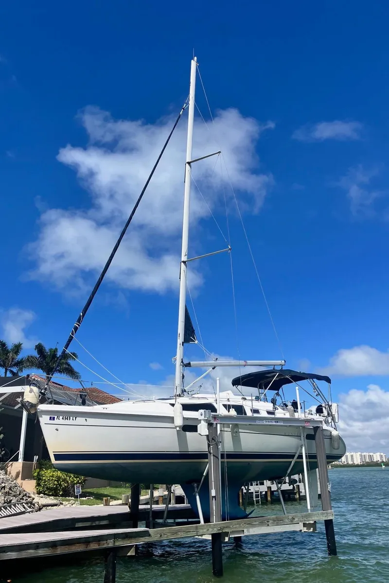 Slide: The Image of 2003 Hunter 326 sailboat docked under a clear blue sky. - 0