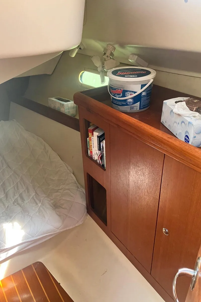 Slide: The Image of Interior cabin of a 2003 Hunter 326 sailboat with wooden cabinetry and bedding. - 13