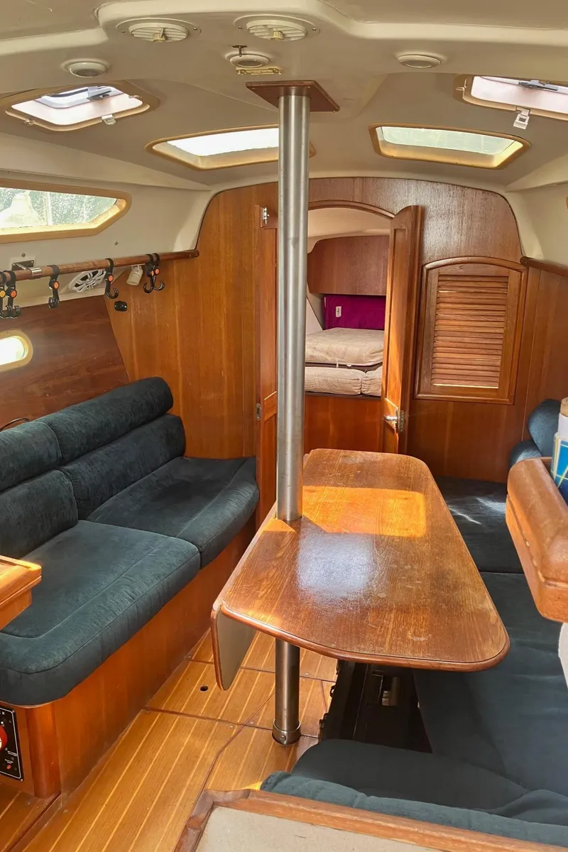 Slide: The Image of Interior of a 2003 Hunter 326 sailboat with wooden furnishings and seating area. - 15