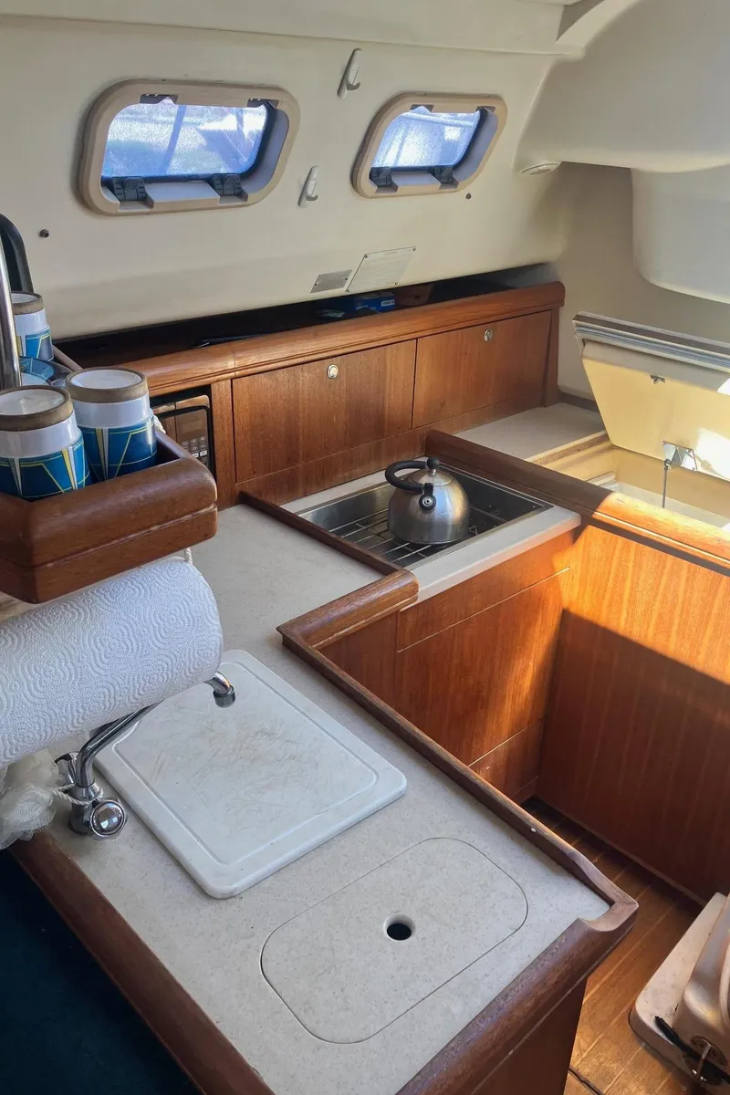 Slide: The Image of 2003 Hunter 326 yacht interior kitchen with wooden cabinets and sink. - 7