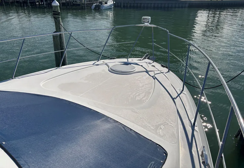 Slide: The Image of 2006 Cruisers Yachts 415 Express Motoryacht bow view, docked in calm waters. - 11