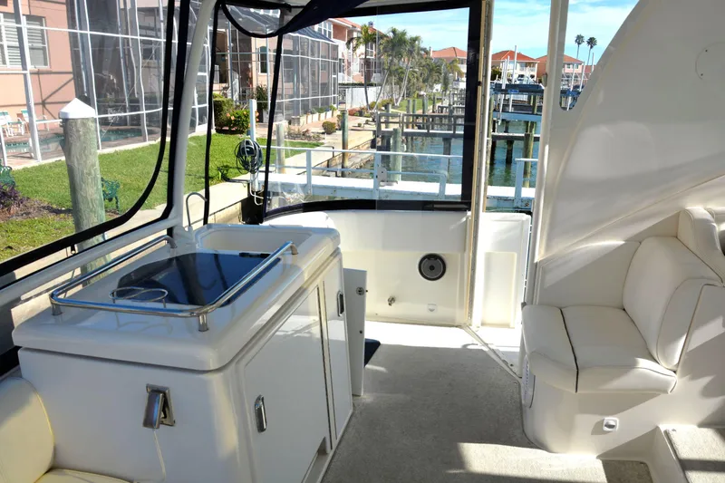 Slide: The Image of 2006 Cruisers Yachts 415 Express Motoryacht interior with seating and kitchenette, docked at marina. - 13