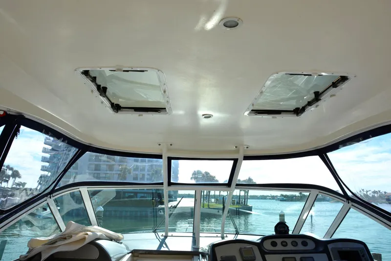 Slide: The Image of Interior view of 2006 Cruisers Yachts 415 Express Motoryacht helm with waterfront backdrop. - 17
