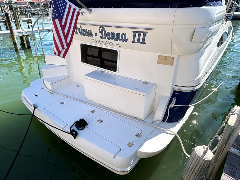 Slide: The Image of 2006 Cruisers Yachts 415 Express Motoryacht docked, displaying American flag. - 3