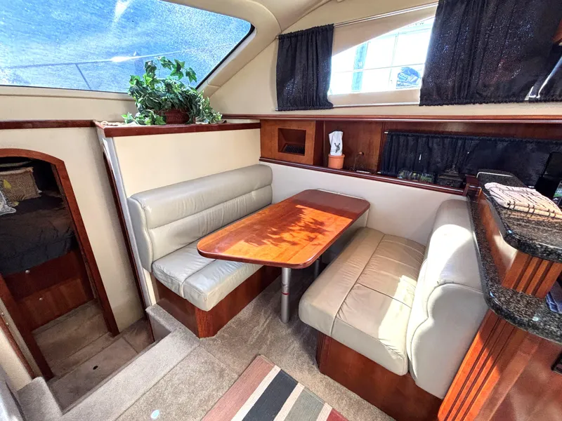 Slide: The Image of 2006 Cruisers Yachts 415 Express Motoryacht interior with dining area, leather seating, and wooden table. - 38