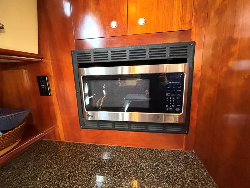Slide: The Image of Microwave in 2006 Cruisers Yachts 415 Express Motoryacht kitchen with wood cabinetry. - 41