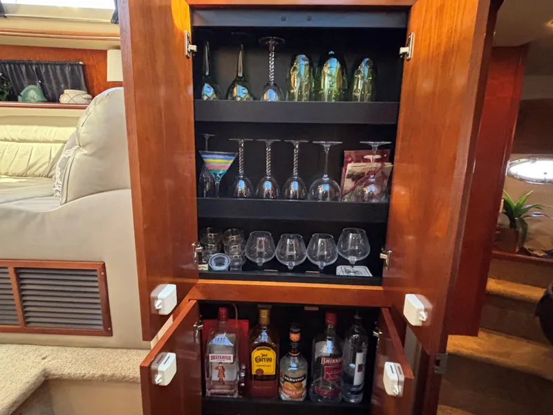 Slide: The Image of Bar cabinet with glassware and liquor bottles in 2006 Cruisers Yachts 415 Express Motoryacht. - 43