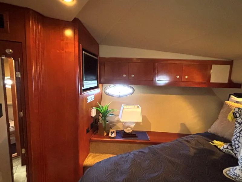 Slide: The Image of Luxurious 2006 Cruisers Yachts 415 Express Motoryacht cabin interior with wood paneling and cozy bedding. - 46