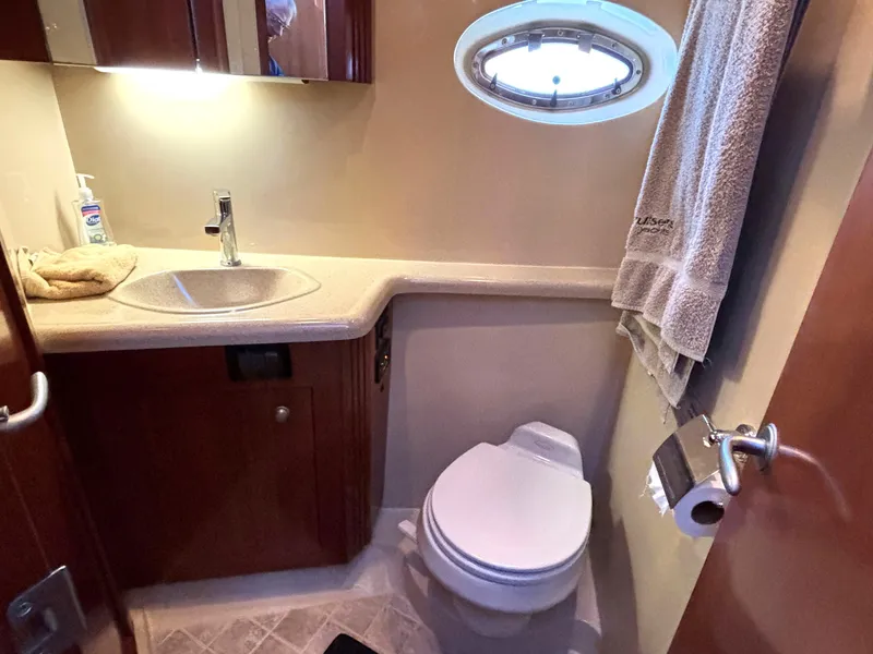 Slide: The Image of 2006 Cruisers Yachts 415 Express Motoryacht bathroom with sink, toilet, and porthole window. - 49