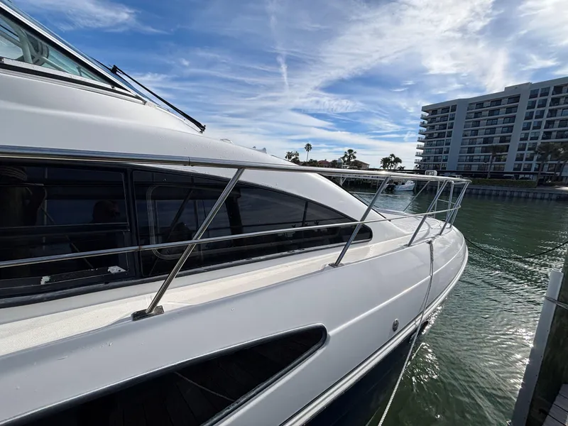 Slide: The Image of 2006 Cruisers Yachts 415 Express Motoryacht docked by waterfront building. - 7