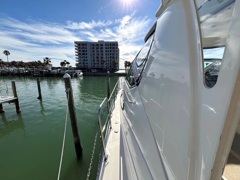 Slide: The Image of 2006 Cruisers Yachts 415 Express Motoryacht docked by waterfront buildings under a sunny sky. - 9