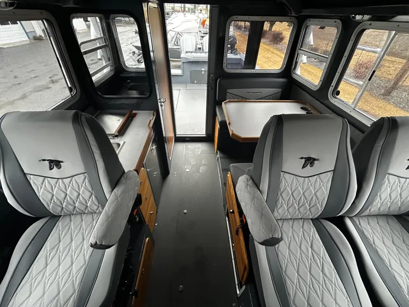Slide: The Image of Interior of 2025 Duckworth 30 XL boat with gray quilted seats and large windows. - 16