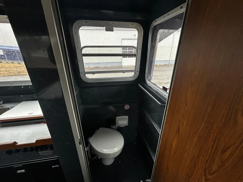 Slide: The Image of Interior of 2025 Duckworth 30 XL boat featuring a compact bathroom with window. - 8