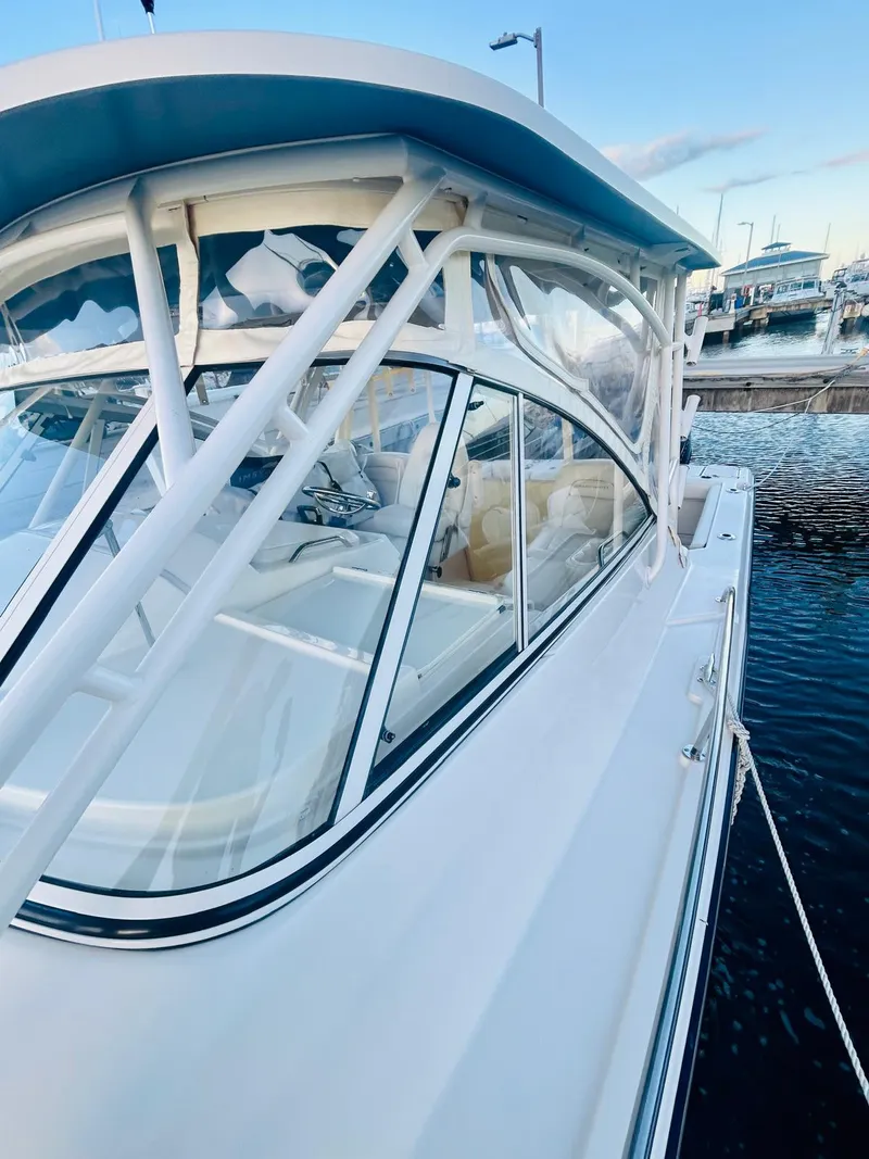 Slide: The Image of 2021 Grady-White Express 330 boat docked at marina, showcasing sleek design and spacious cabin. - 12