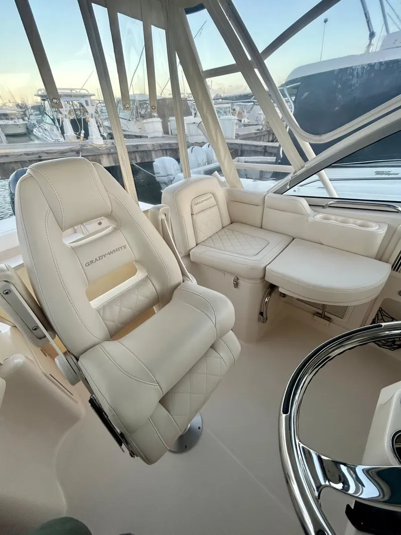 Slide: The Image of 2021 Grady-White Express 330 boat interior with plush seating and steering wheel. - 18