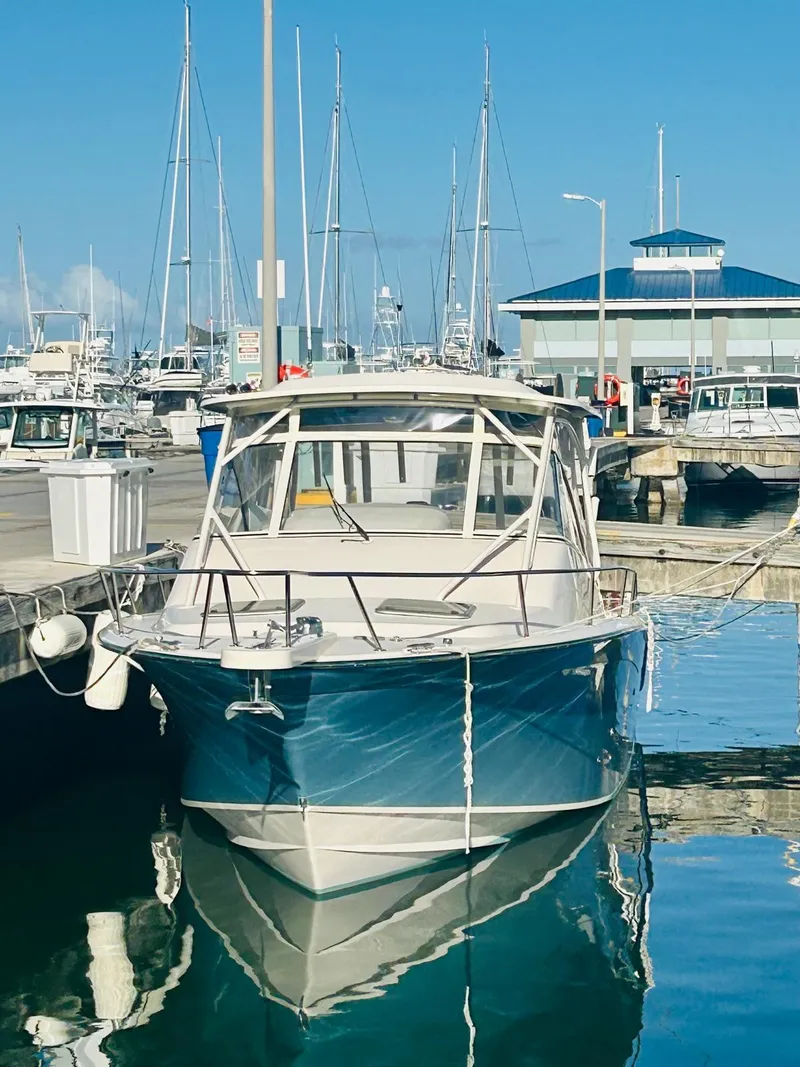 Slide: The Image of 2021 Grady-White Express 330 boat docked at a marina with clear blue skies. - 2