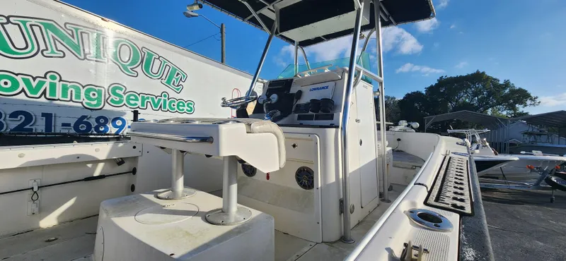 Slide: The Image of 1999 Robalo 2420 Center Console boat with seating and control panel, parked outdoors. - 4