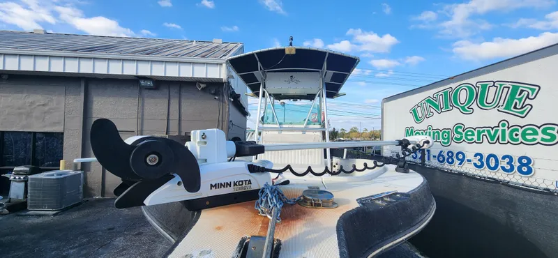 Slide: The Image of 1999 Robalo 2420 Center Console boat with Minn Kota motor, parked near Unique Moving Services. - 5