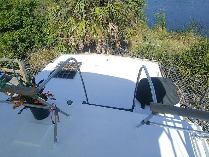 Slide: The Image of 1975 Marine Trader 40 Double Cabin deck with railing, surrounded by lush greenery. - 14