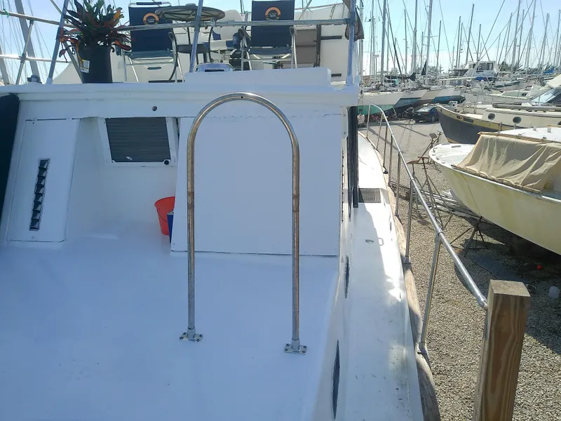 Slide: The Image of 1975 Marine Trader 40 Double Cabin yacht docked in a marina, featuring a spacious deck. - 17