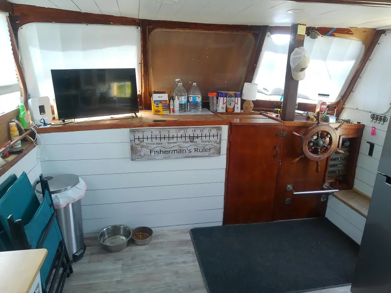 Slide: The Image of 1975 Marine Trader 40 Double Cabin interior with helm, TV, and nautical decor. - 25