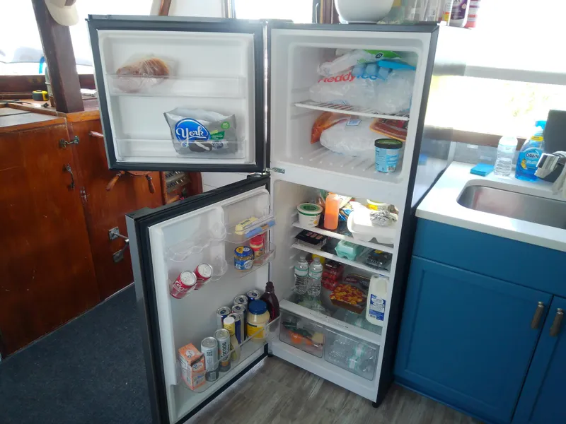 Slide: The Image of Refrigerator stocked with food and drinks inside a 1975 Marine Trader 40 Double Cabin boat. - 29