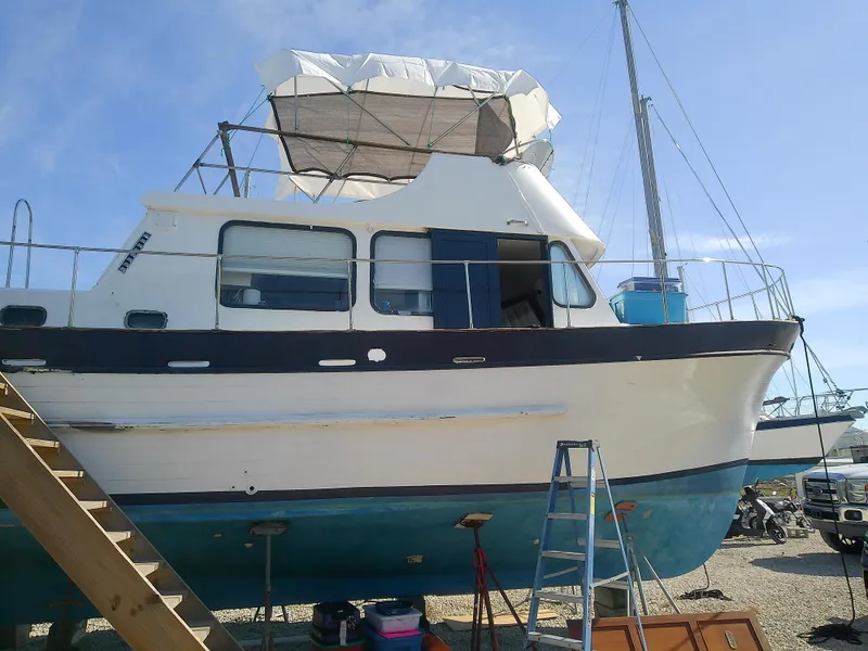 Slide: The Image of 1975 Marine Trader 40 Double Cabin boat on dry dock with ladder and tarp cover. - 3
