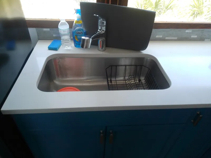 Slide: The Image of 1975 Marine Trader 40 Double Cabin kitchen sink with faucet and cleaning supplies. - 30