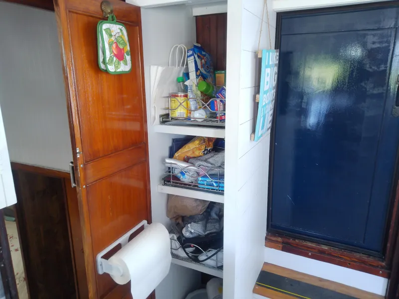 Slide: The Image of 1975 Marine Trader 40 Double Cabin interior storage with wooden cabinet and shelves. - 35