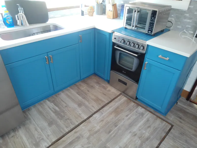 Slide: The Image of 1975 Marine Trader 40 Double Cabin kitchen with blue cabinets and modern appliances. - 36