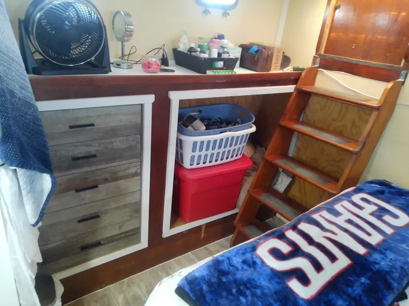 Slide: The Image of 1975 Marine Trader 40 Double Cabin interior with storage, fan, and stairs. - 38