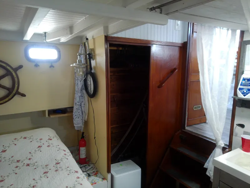 Slide: The Image of 1975 Marine Trader 40 Double Cabin interior with wooden stairs, nautical decor, and floral bedding. - 42