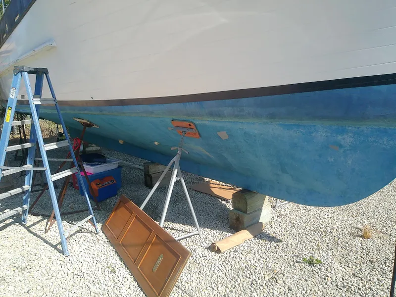 Slide: The Image of 1975 Marine Trader 40 Double Cabin boat on stands, with ladder and tools nearby. - 9