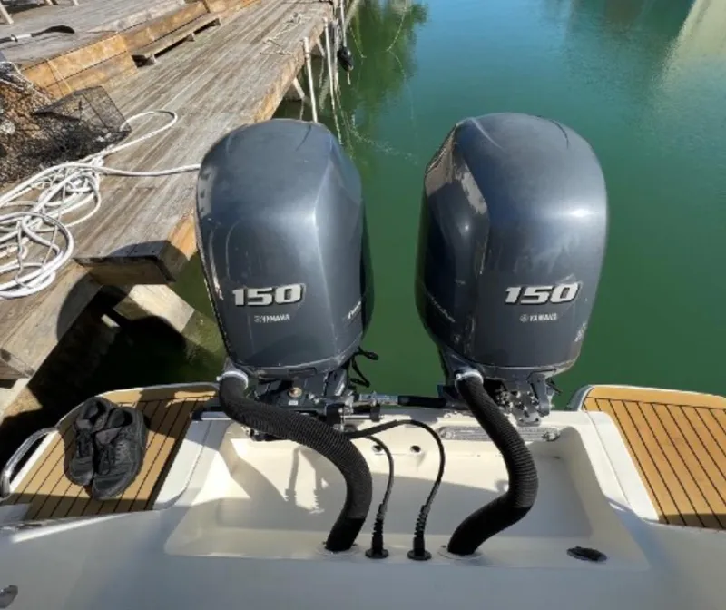 Slide: The Image of 2013 Scout 275 LXF boat with twin Yamaha 150 engines docked by wooden pier. - 15