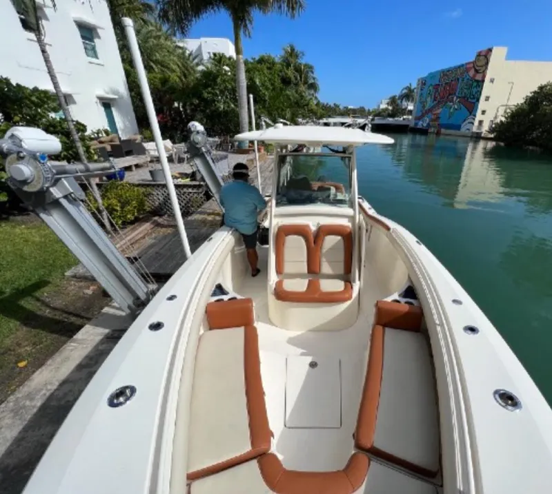 Slide: The Image of 2013 Scout 275 LXF boat docked by a canal with palm trees. - 17