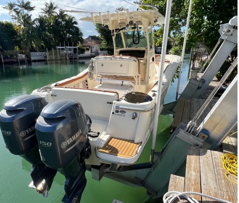 Slide: The Image of 2013 Scout 275 LXF boat with dual Yamaha engines docked by a scenic waterfront. - 9