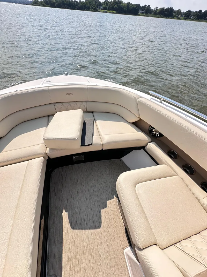 Slide: The Image of 2019 Regal 29 OBX boat interior with beige seating on a calm lake. - 18