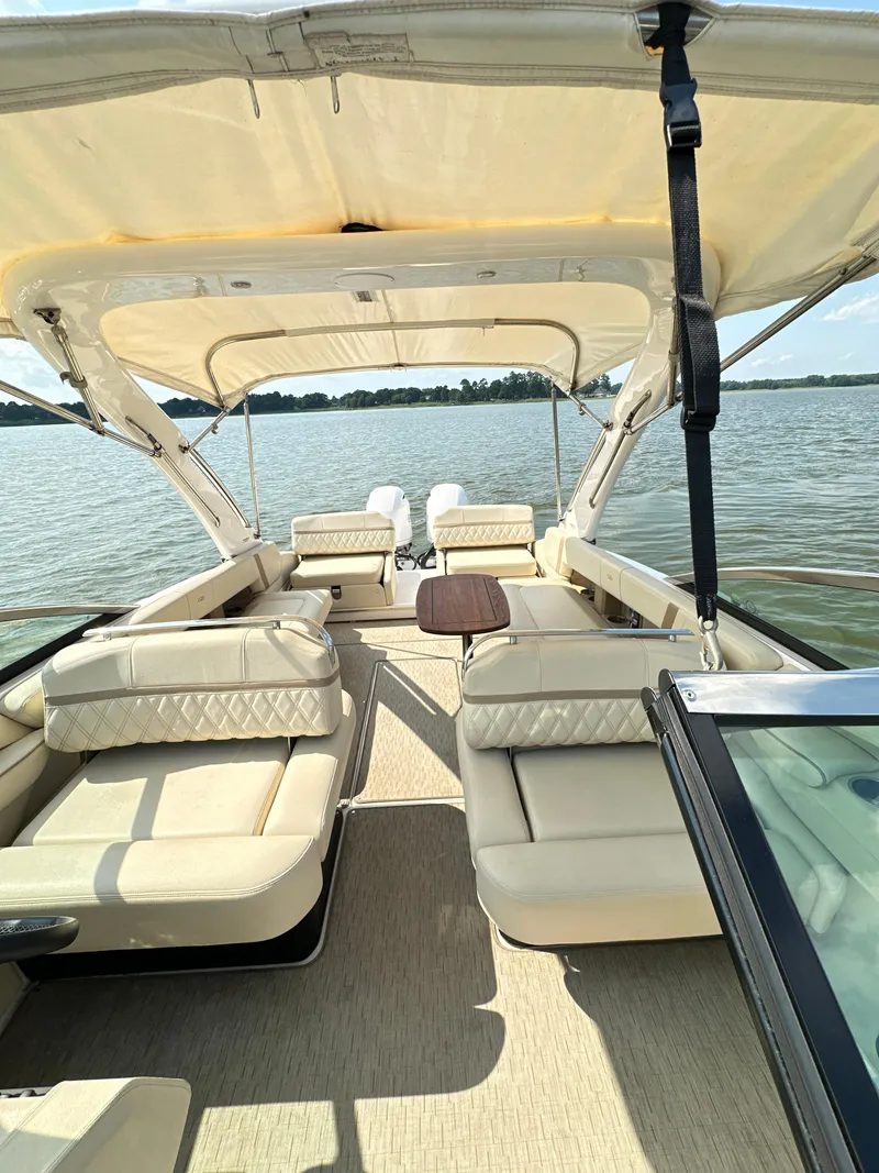 Slide: The Image of 2019 Regal 29 OBX boat with spacious seating and canopy on a calm lake. - 20