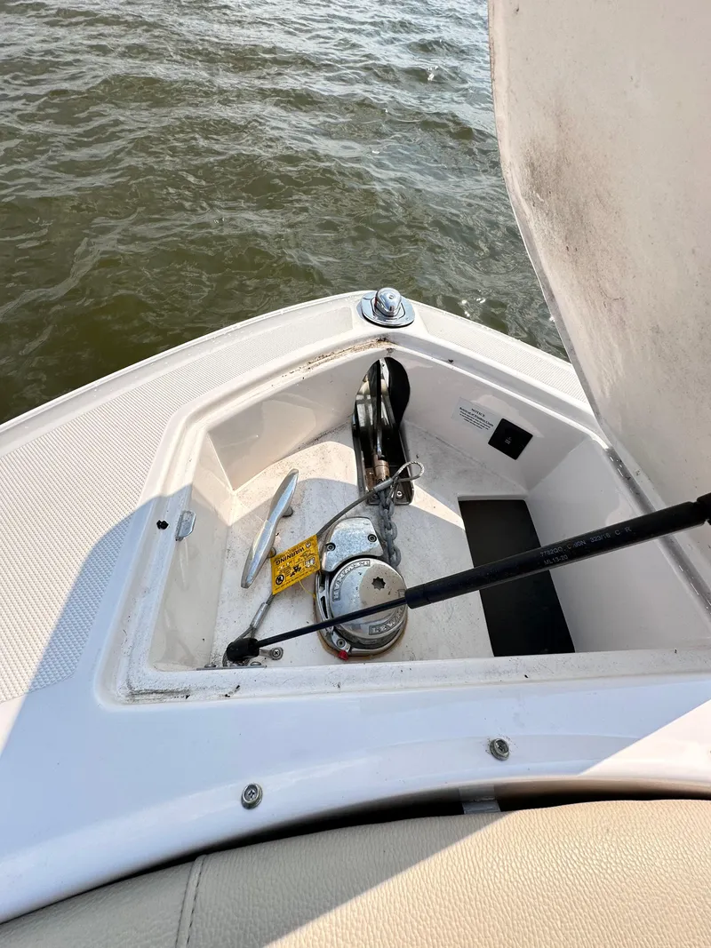 Slide: The Image of 2019 Regal 29 OBX boat anchor compartment with open hatch on water. - 44